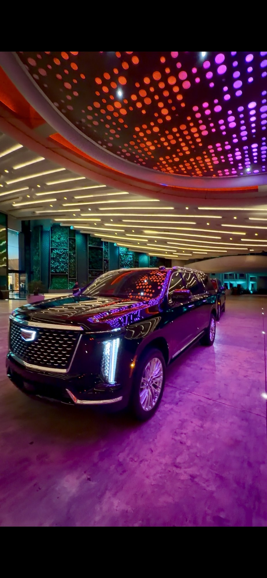 Black Cadillac Escalade at an illuminated hotel entrance